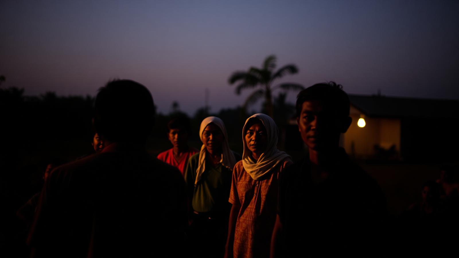 Community workers gathered in a village at dusk